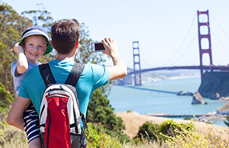 Father and son taking picture of the bridge.